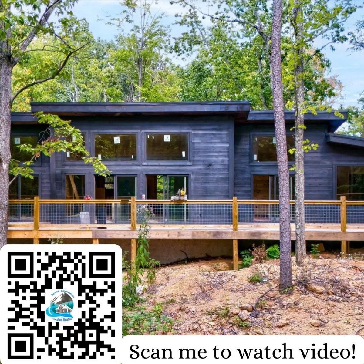 The image showcases the modern wooden exterior of a brand-new cabin, featuring expansive windows that flood the interior with light. The spacious deck with sleek railings invites guests to take in the surrounding lush trees and tranquil natural setting, perfect for unwinding. The scene captures the golden glow of sunset, hinting at peaceful evenings spent outdoors.